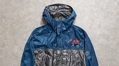 ST95 Archive Piece 001 Jacket in blue and silver with hooded design, lightweight fabric and chest patch detail.