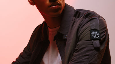 Close-up of the ST95 Overshirt 03 in dark grey, featuring the signature ST95 globe logo patch on the sleeve.