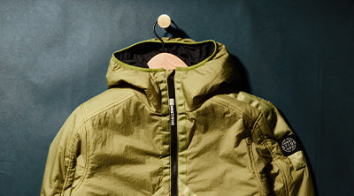 ST95 Helio Hooded Padded Blouson in light green, featuring diagonal zip detail, and sleeve logo badge.