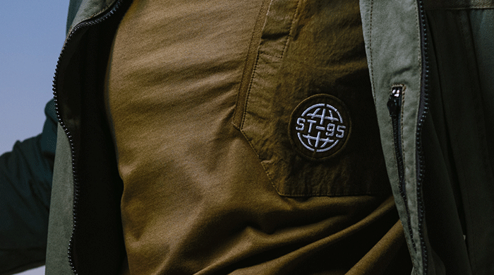 Close-up of the ST95 Long Sleeve Seasonal T-Shirt in brown, featuring chest pocket with embroidered ST95 globe logo.