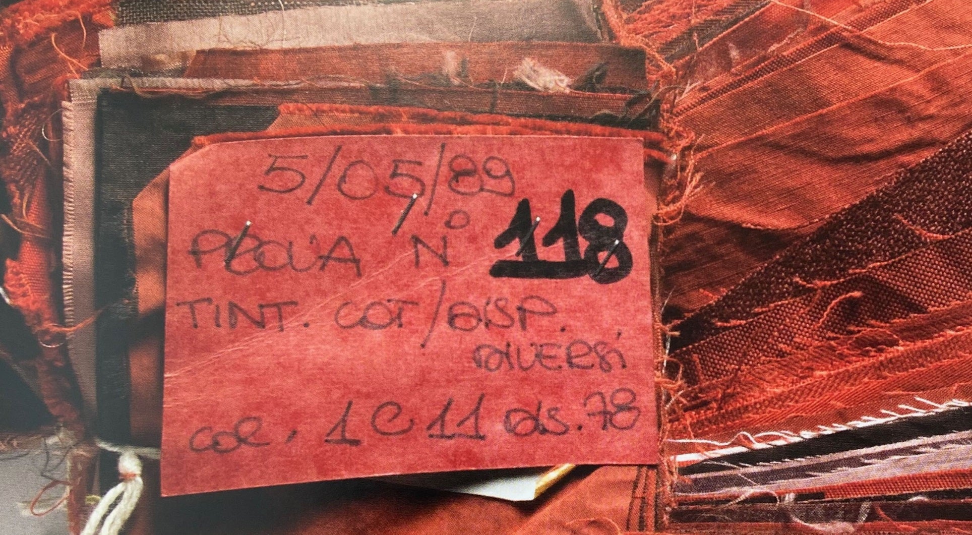 Close-up of a red label with text and numbers on a textured surface